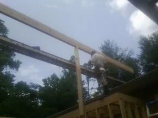 Carpenter setting a ridge beam over a new addition frame — Ice Dam Removal by Roofing Brothers in Ventnor City