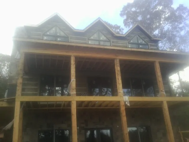 Dormers and porch framing on a large log home under construction — Roof Coating work by our crew in Ventnor City
